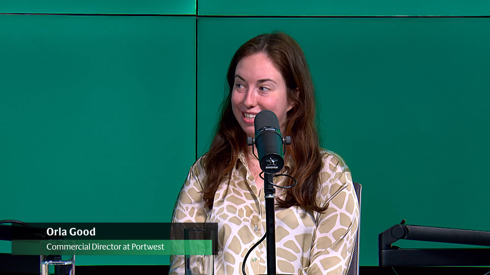 A person sitting in front of a microphone doing a podcast